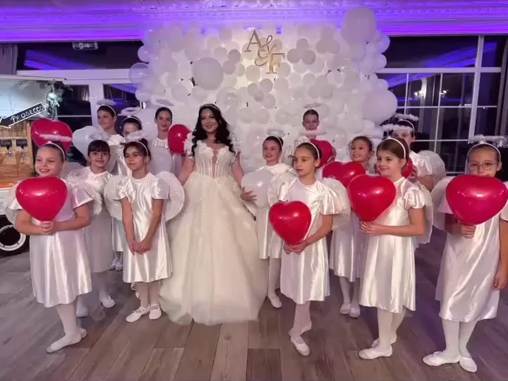 Emilia Oprea în rochie albă, alături de grupul de eleve în ținute albe, la un spectacol Top Dance