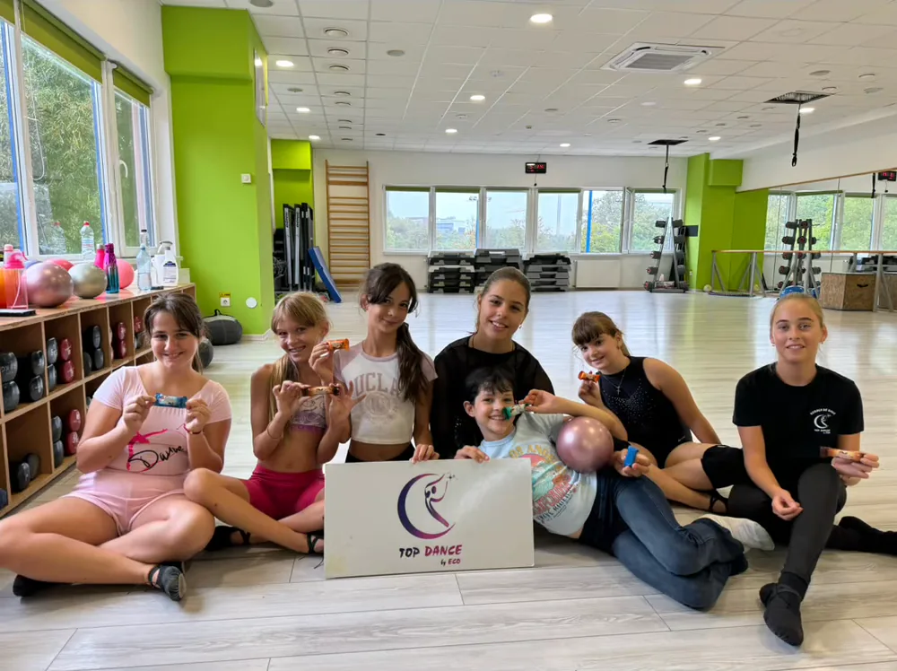 Grup de eleve Top Dance în sala de dans, cu sigla școlii